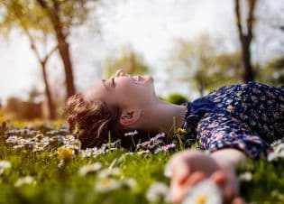 Pretty young teenage girl laying on a grass